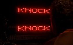 An LED lightboard spelling out two words in red letters: KNOCK KNOCK.
